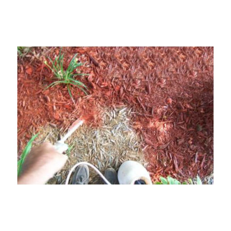 Garden Bed With Red Mulch And Green Plants Along Lawn Edge