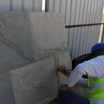 Worker Applying Concrete Stain On Precast Warehouse Wall