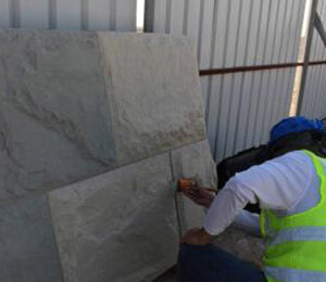 Worker Applying Concrete Stain On Precast Warehouse Wall