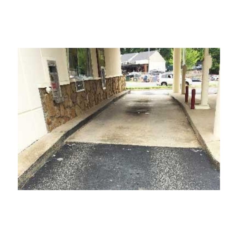 Asphalt Ramp With Concrete Curbs And Adjacent Posts At Driveway