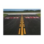 Painted Runway Markings On Asphalt Surface Near Aircraft Hangar