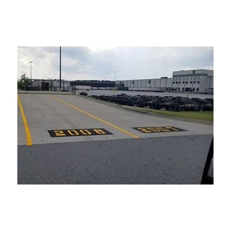 Large Yellow Directional Text Painted On Warehouse Lot Pavement